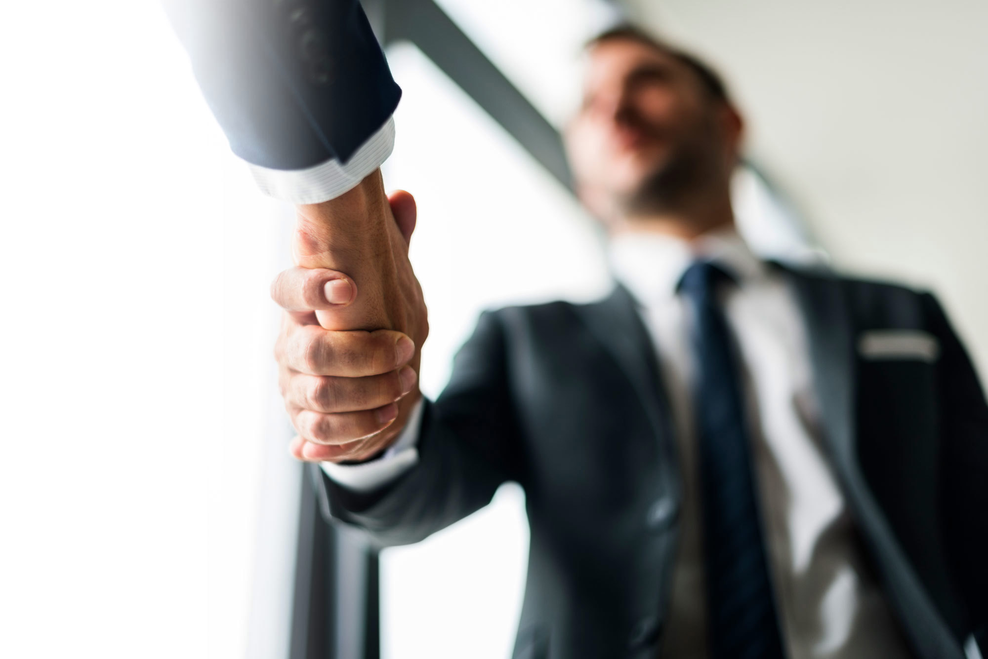 Two business professionals shaking hands, symbolizing agreement or partnership.